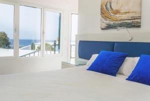 a bedroom with a bed with a blue headboard and windows at El Hotelito Del Golfo in El Golfo