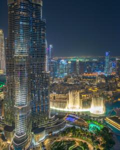 uma vista da cidade à noite com uma fonte em FIRST CLASS 3BR with full BURJ KHALIFA and FOUNTAIN VIEW em Dubai