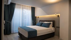 a bedroom with a large bed with blue pillows at OPERA SUITES Apart Hotel in Antalya