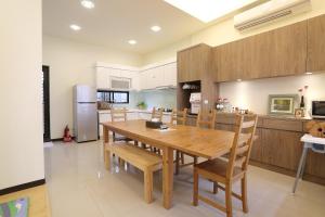 a kitchen and dining room with a wooden table and chairs at Forest Park Homestay in Dongshan