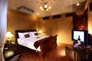 a bedroom with a large bed and a television at Ruen Ariya Resort in Mae Rim