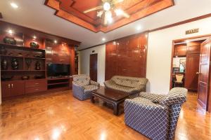a living room with chairs and a table and a tv at Ruen Ariya Resort in Mae Rim