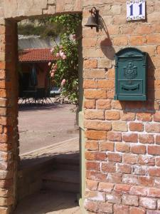 un buzón verde al lado de una pared de ladrillo en Guest House I Vicini di Cesare, en Castelnuovo