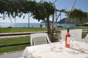 una botella de vino sentada en una mesa con copas de vino en ELIAS & VASILI HOUSE, en Agios Georgios Pagon