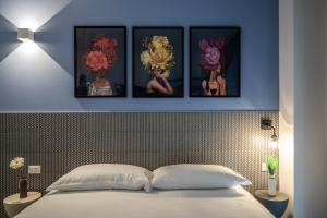 a bedroom with four pictures on the wall above a bed at SEI Garda Apartments in Peschiera del Garda +57 photos
