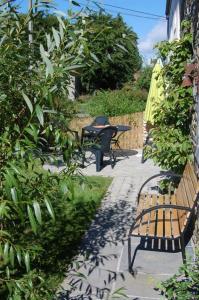 a patio with two benches and a table at Le Clos des Haies, Silenrieux in Cerfontaine