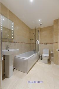 Edinburgh City Suites في إدنبرة: حمام مع حوض ومغسلة ومرحاض