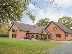 a brick house with a black roof at Oak Lodge in Hadnall