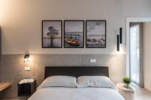 a bedroom with a bed with four pictures on the wall at SEI Garda Apartments in Peschiera del Garda
