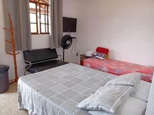 a bedroom with a bed and a chair in it at Pousada Bergehaus in Domingos Martins