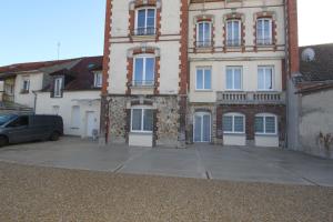 a building with a car parked in front of it at Le First by EasyEscale in Romilly-sur-Seine