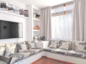 sala de estar con sofá y TV de pantalla plana en VULCANO APARTMENT LANZAROTE, en Costa Teguise