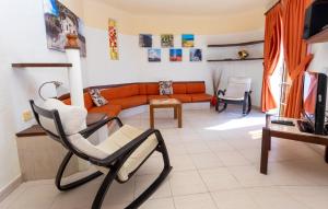 een woonkamer met een bank en een stoel bij Altamar 44 balcony&pool By CanariasGetaway in Playa del Aguila