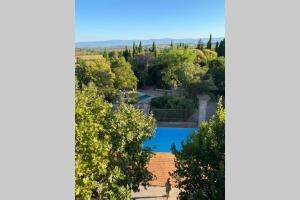 una vista aérea de una villa con piscina y árboles en Cave atelier dans ancien domaine viticole, en Moux