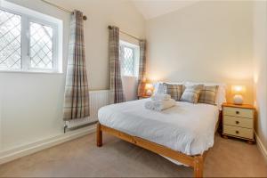 a bedroom with a bed and a window at Guest Homes - The Old Thatch in Bredon
