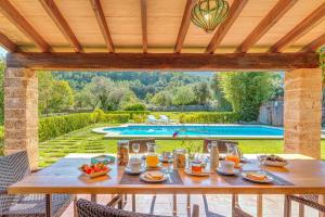 een tafel met eten en drinken op een patio met een zwembad bij Can Peric in Pollença