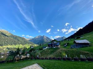 Blick auf einen grünen Hügel mit Bergen im Hintergrund in der Unterkunft bi dr Gondamaika in Hirschegg