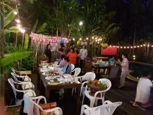 a group of people sitting at tables in a restaurant at Ruen Ariya Resort in Mae Rim +71 photos