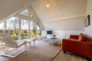 sala de estar con sofá, sillas y lámpara de araña en Gästehaus Drostenhof en Rees