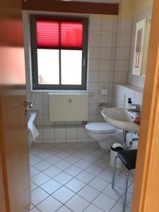 uma casa de banho com um lavatório, um WC e uma janela. em Ferienwohnungen am Schloss em Wittenberg