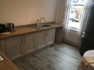 a kitchen with a sink and a counter with a window at Elmdon Lodge in Birmingham