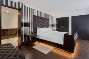 a bedroom with a large bed and a television at Hotel Retlaw, Trademark Collection by Wyndham in Fond du Lac +35 photos