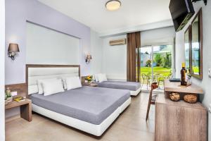 a bedroom with two beds and a balcony at Iris Hotel in Siviri