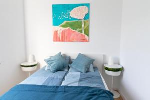 a bedroom with a blue bed with two lamps at Apartamenty na Wzgórzu in Bochnia