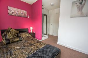una camera con una parete rosa e un letto di Brighton Townhouse - Central- by Brighton Holiday Lets a Brighton & Hove