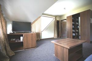 uma sala de estar com televisão e uma grande janela em Hotel Nastup em Dombay