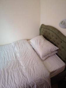a bed with a green headboard and two white pillows at Memory Homes MM H in Manchester