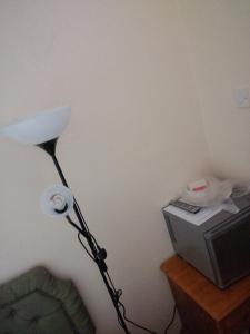 a lamp in the corner of a room next to a television at Memory Homes MM H in Manchester
