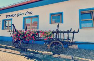 a cart filled with flowers in front of a building at Penzion jako víno in Bulhary