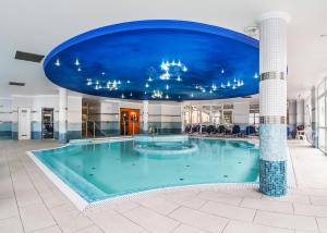 豪伊杜索博斯洛的住宿－白銀酒店，蓝色天花板建筑中的一个大型游泳池