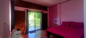a bedroom with a red bed and a large window at หลับสบายที่ดอยตุง Zuh meh ja Home lodge in Ban Pa Kluai La Hu