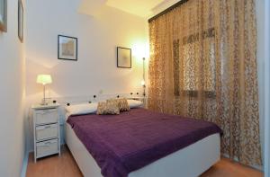 a bedroom with a purple bed and a window at Apartments Jadranka 1279 in Pomer