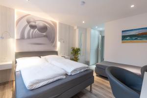 a bedroom with a bed and a blue chair at Messe-Hotelzimmer-Einzimmerappartement in Leverkusen