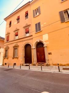 ein orangefarbenes Gebäude mit zwei Türen auf einer Straße in der Unterkunft Studio de Poeti in Bologna