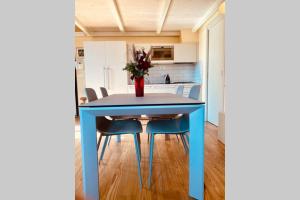 a blue table in a kitchen with a vase of flowers at Studio de Poeti in Bologna +5 photos