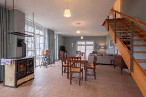 a living room with a staircase and a dining room at Herrenhaus Jürgenshof - Ferienhaus in Alt Schwerin