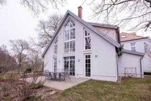 a white house with a table on a patio at Herrenhaus Jürgenshof - Ferienhaus in Alt Schwerin