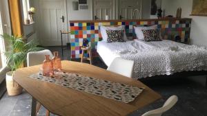 瓦尔韦克B&B de Loeff的客房设有桌子、床和桌椅。