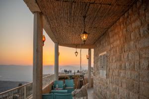 balkon z krzesłami i widokiem na ocean w obiekcie צימר old school בחרמון לזוגות ומשפחות w mieście Ein Kinya