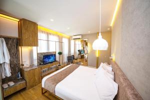 1 dormitorio con 1 cama grande y TV en Green Terrace Apartments Tirana, en Tirana