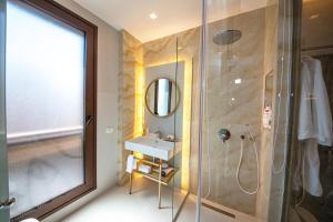 y baño con ducha, lavabo y espejo. en Green Terrace Apartments Tirana, en Tirana