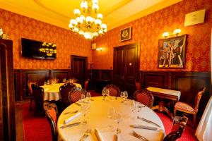 une salle à manger avec des tables et des chaises ainsi qu'un lustre dans l'établissement Picasso Boutique Hotel, à Arad