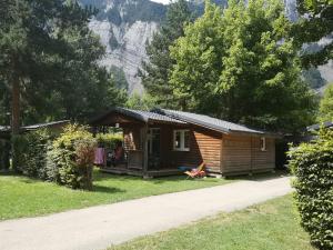 eine Hütte in den Bergen mit einer Person, die davor sitzt in der Unterkunft Camping Le Colporteur in Le Bourg-dʼOisans