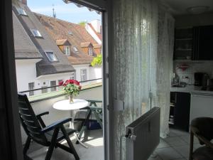 a balcony with a table with a vase of flowers at FeWo - Mitten In Freiburg in Freiburg im Breisgau +3 photos