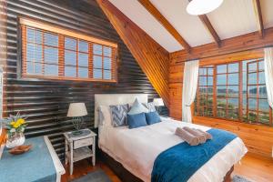 a bedroom with a bed in a room with wooden walls at Big Tree House Lodge in Knysna