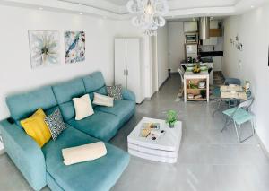 ein Wohnzimmer mit einem blauen Sofa und einem Tisch in der Unterkunft COSY MODERN HOUSE - CENTER ALBUFEIRA - OLD TOWN in Albufeira